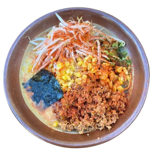 Sapporo Ramen bowl with bean sprouts, corn, ground meat, seaweed, and chili powder.