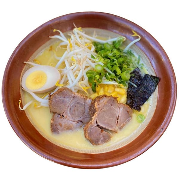 Sapporo Ramen with pork, egg, bean sprouts, corn, green onions, and nori in a brown bowl.