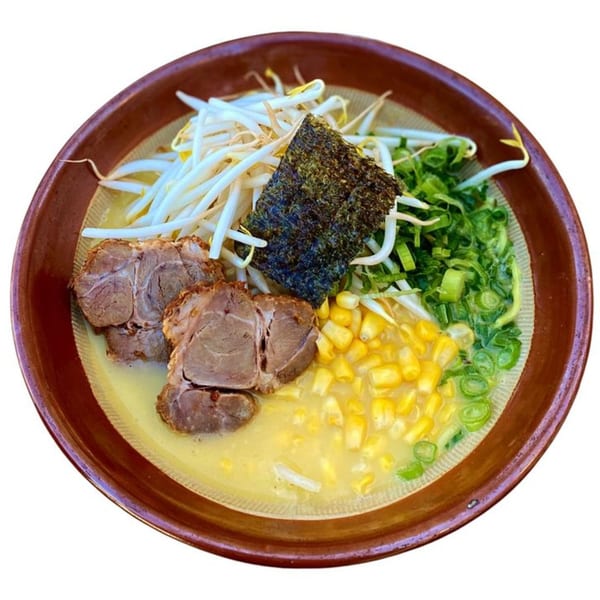 Sapporo Ramen with pork, bean sprouts, corn, green onions, and nori in a brown bowl.