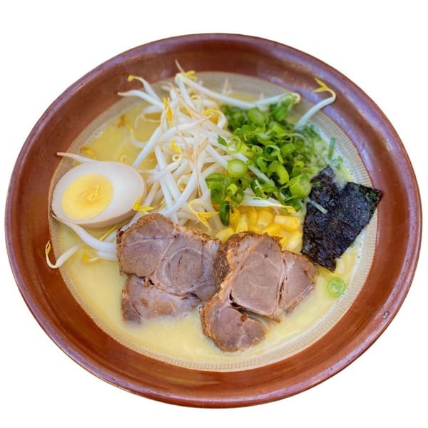 Sapporo Ramen with pork, egg, bean sprouts, corn, green onions, and nori in a brown bowl.